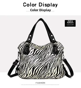 Detail view of zebra print tote bag featuring black leather handles and silver rivets