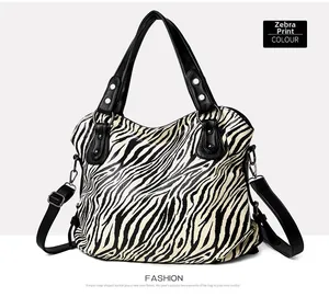 Close-up of zebra print tote bag with adjustable black shoulder straps and metal hardware