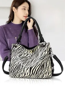 Detail of zebra pattern tote bag with adjustable shoulder strap and black handles