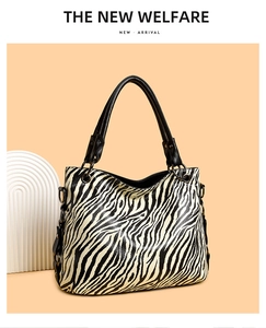 Close-up of zebra pattern tote bag with leather handles and metal D-ring details