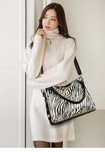 Close-up of zebra pattern tote bag on model showing premium leather texture and strap