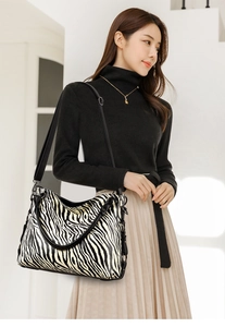 Detail of zebra print tote bag with adjustable wide strap and metal hardware