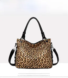 Front view of leopard print tote bag with black leather handles and metal hardware