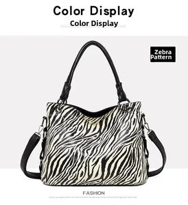 Detail view of large zebra print tote bag featuring black leather straps and silver rings
