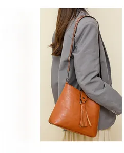 Sac seau vintage ambre avec détail de gland et bandoulière large élégante
