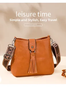 Détail du sac seau marron caramel avec pompon à anneau et bandoulière en jacquard