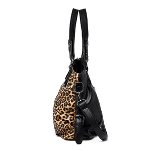 Leopard print and black leather tote bag with shoulder strap shown from a side view