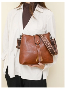 Détail du sac bandoulière marron vintage avec franges et sangle à motif lapin