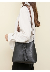 Détail du sac hobo noir avec des franges décoratives et une bandoulière en jacquard