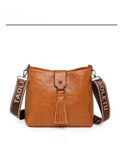Vue de face du sac seau vintage marron avec glands en cuir et large bandoulière