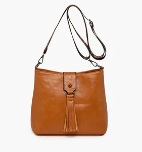 Détail du sac en similicuir caramel avec pampille élégante et finitions argentées