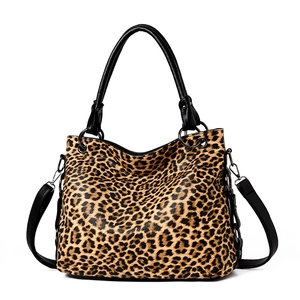 Large leopard print tote bag with black leather handles and adjustable shoulder strap