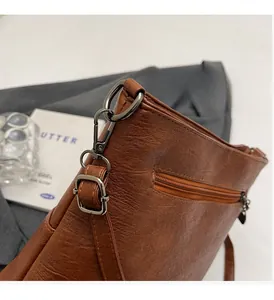 Detail of brown vintage leather texture with gun-metal buckle and zip pocket
