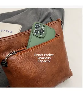 Detail of brown litchi pattern leather bucket bag with zipper pocket and phone size comparison