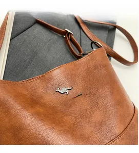 Close-up of caramel brown pebble leather texture with golden kangaroo logo detail