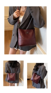 Detail view of burgundy leather shoulder bag featuring silver metal kangaroo logo accents