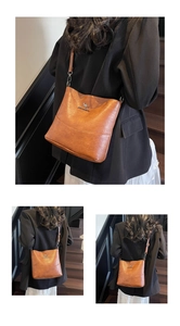 Detailed view of a brown crossbody bag with a metal kangaroo logo and slim strap