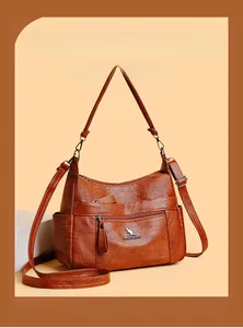 Detailed view of brown leather handbag texture with zip pocket and brand logo