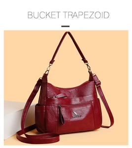 Close-up of wine red litchi texture faux leather bag with metal kangaroo logo detail