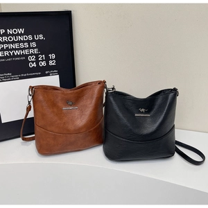 Detailed view of soft leather cross-body bags with kangaroo logo and fine litchi texture