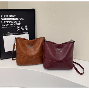 Detail view of the fine retro faux leather texture and kangaroo metal logo on the bag