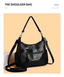 Detail of black faux leather shoulder bag with zipper pocket and kangaroo logo on pedestal