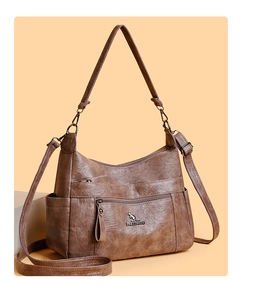 Close-up of brown leather crossbody bag featuring metal kangaroo logo and zipper detail