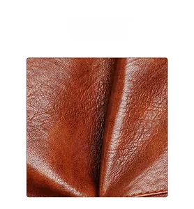 Close-up of caramel leather texture showing fine grain and soft folds on a handbag