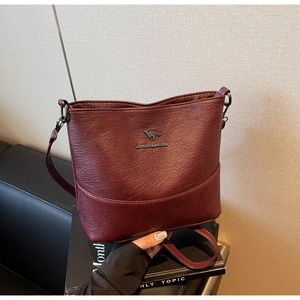 Close-up of wine red bucket bag featuring lychee texture leather and kangaroo logo