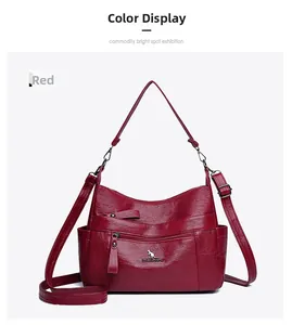 Detail of burgundy faux leather handbag with lychee texture and metallic kangaroo icon
