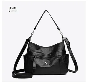 Close-up of black oily wax leather shoulder bag with logo and metallic zipper detail