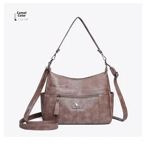 Detail of camel leather handbag with lychee texture and metallic kangaroo logo