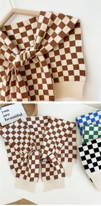 Detail of checkered knit shawl in various colors with a stylish tie-knot design