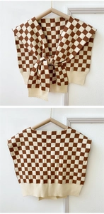 Detail of checkered knit shawl with brown and beige patterns and front knot tie design