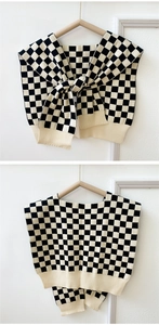 Detail of checkered knit shawl showing soft texture and contrast ribbed hem finishing