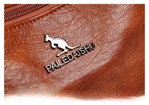 Close-up of brown leather texture with silver kangaroo metal logo and premium zipper