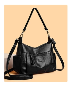 Macro view of black cross-body bag with pebble grain leather and embossed kangaroo logo
