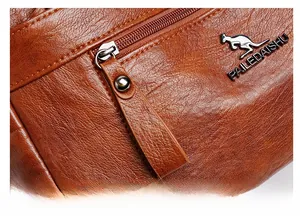 Detail of a brown leather handbag featuring a metal kangaroo logo and a long zipper puller