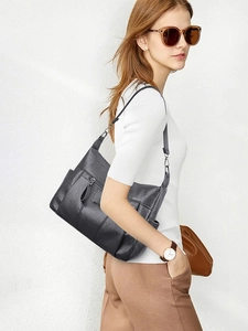 Detail view of large capacity black pebbled leather crossbody bag with multiple zippers
