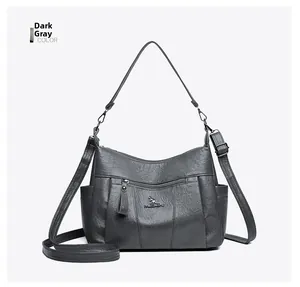 Detail of dark grey textured leather bag with kangaroo logo and adjustable straps