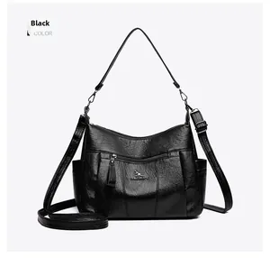 Close-up of black textured leather handbag with kangaroo logo and adjustable shoulder strap