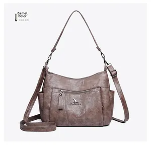 Detail view of camel crossbody bag with kangaroo logo and textured faux leather finish