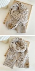 Detailed close-up of beige knit scarf showing hollow diamond pattern and leather logo tag