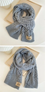 Close-up of grey knit scarf showing hollow wave texture and brown leather brand label