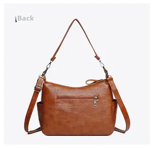 Rear view of brown crossbody bag featuring back zipper pocket and adjustable strap