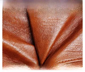 Macro shot of premium brown crossbody bag showing fine leather grain and soft texture