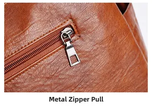 Close-up of premium metal zipper pull on brown lychee texture leather crossbody bag