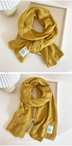 Detail of ginger knit scarf with hollow diamond pattern and brand label on fabric