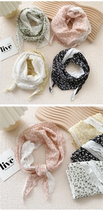 Detailed view of floral embroidery and scalloped edges on colorful triangular scarves