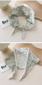 Detail of floral cotton neckerchief with green flower prints and white lace embroidery
